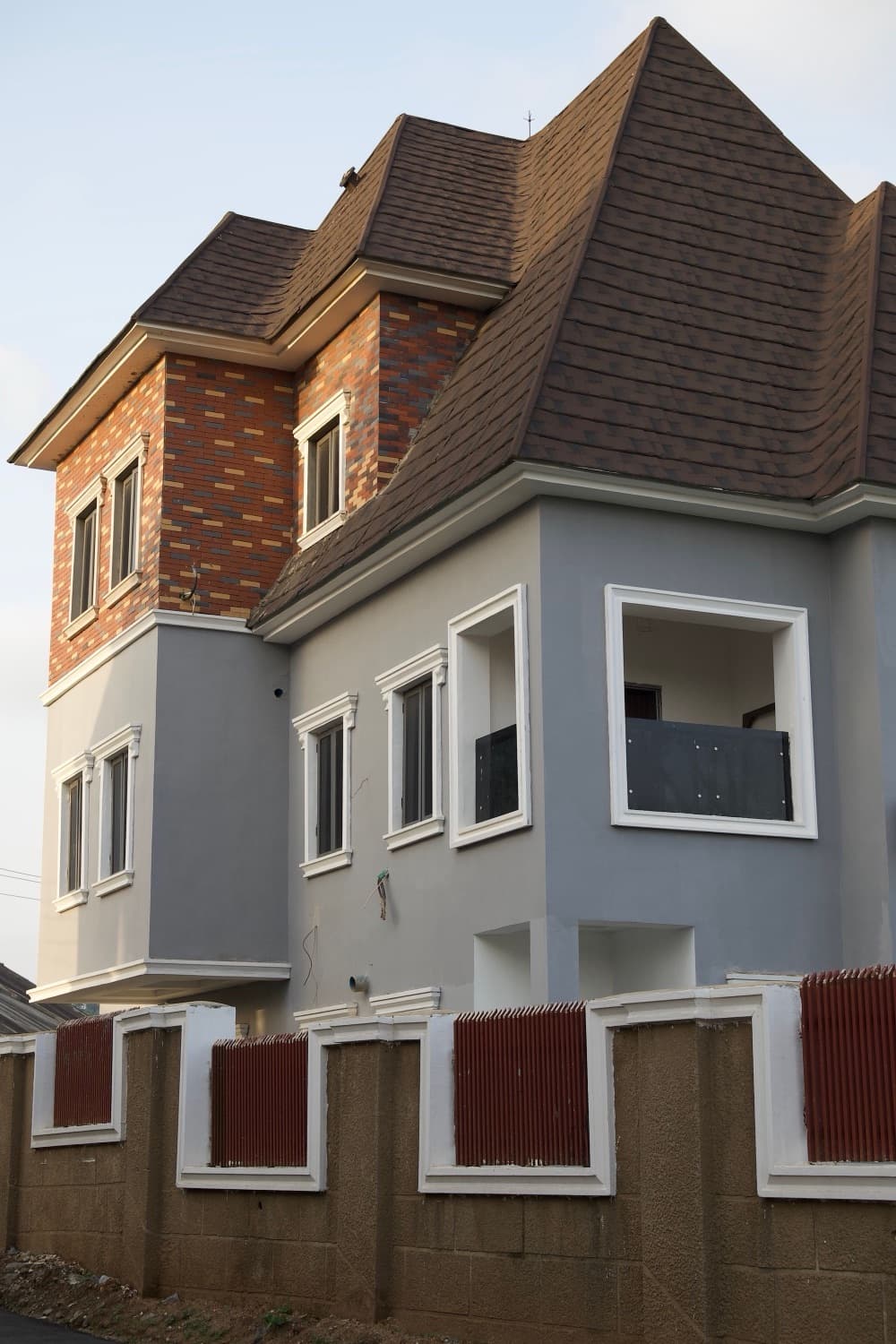 Villa duplex moderne à étage, façade en pierre et enduit clair, en fin de journée