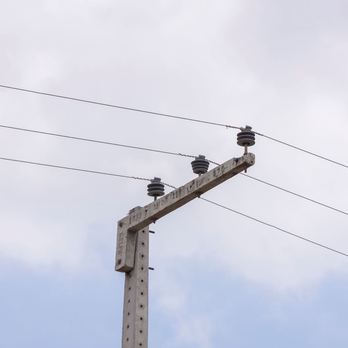 Poteau électrique en béton armé équipé de ses isolateurs et de ses câbles